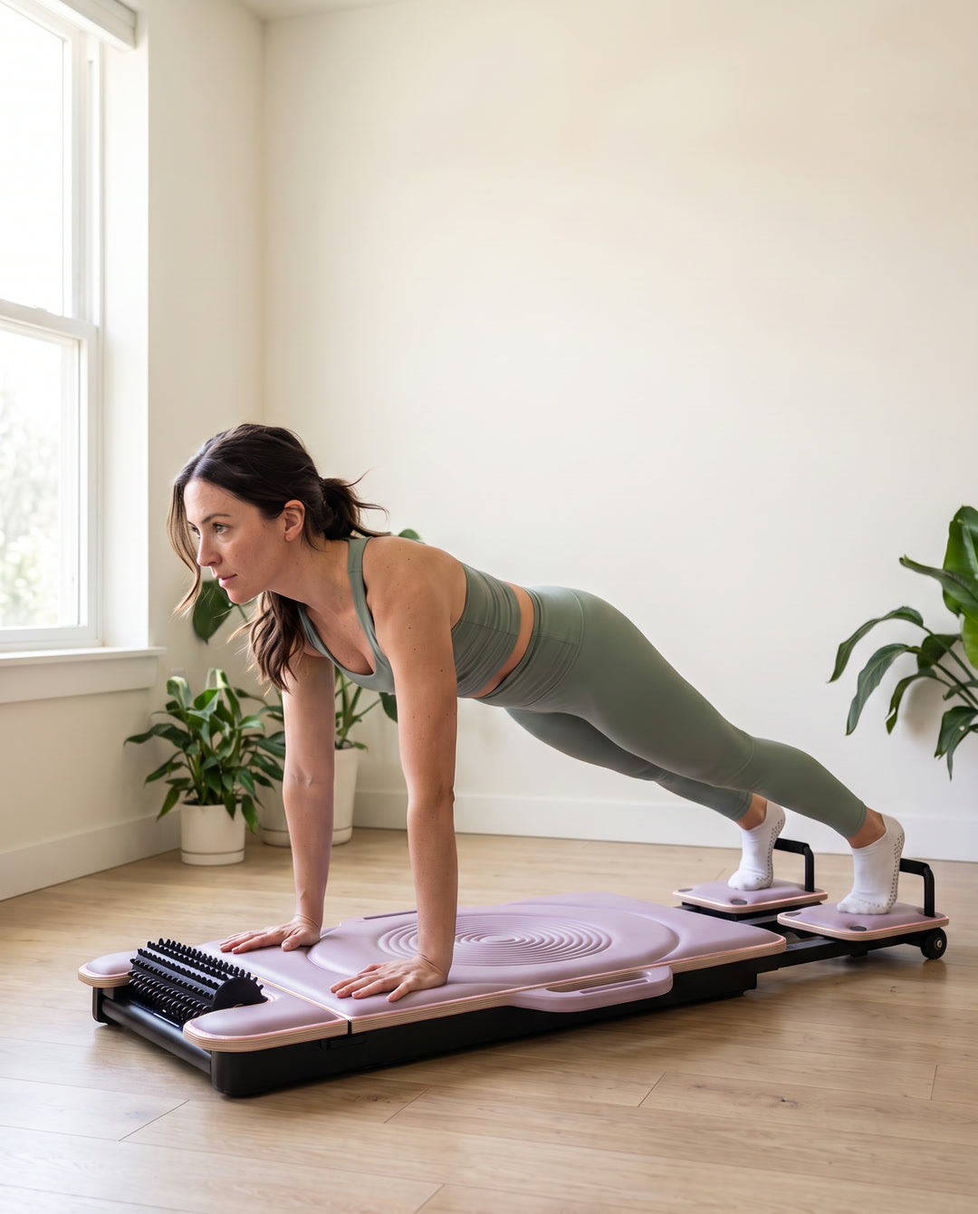 Mujer haciendo una plancha sobre el reformer DROP-IN